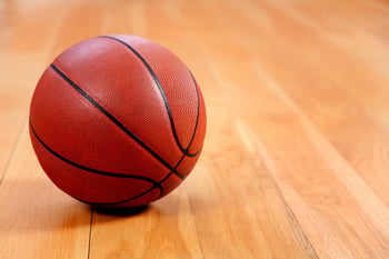 Image of a basketball lying on a wooden floor