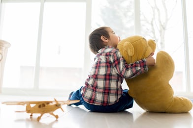 Little baby kid sitting in living room with toy bear | Tips for Finding a Temporary Holiday Job