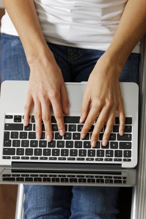 Womans hands typing on a modern laptop computer