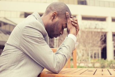 side profile stressed young businessman sitting outside corporate office holding head with hands looking down. Negative human emotion facial expression feelings.-1